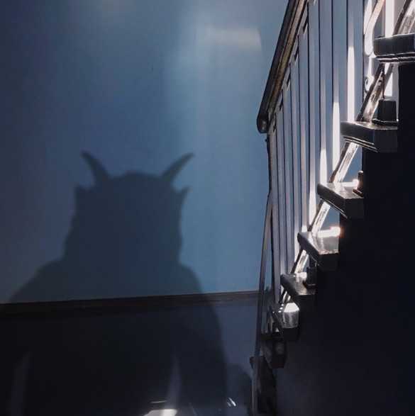 Schatten eines kleinen Monsters mit Hörnern in einem Treppenhaus